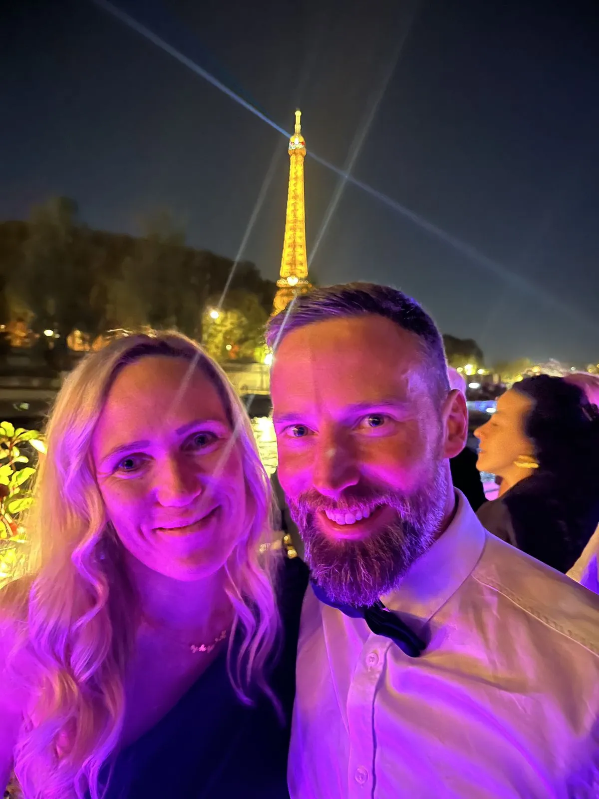 Michael and Verena in the evening in front of the illuminated Eiffel Tower
