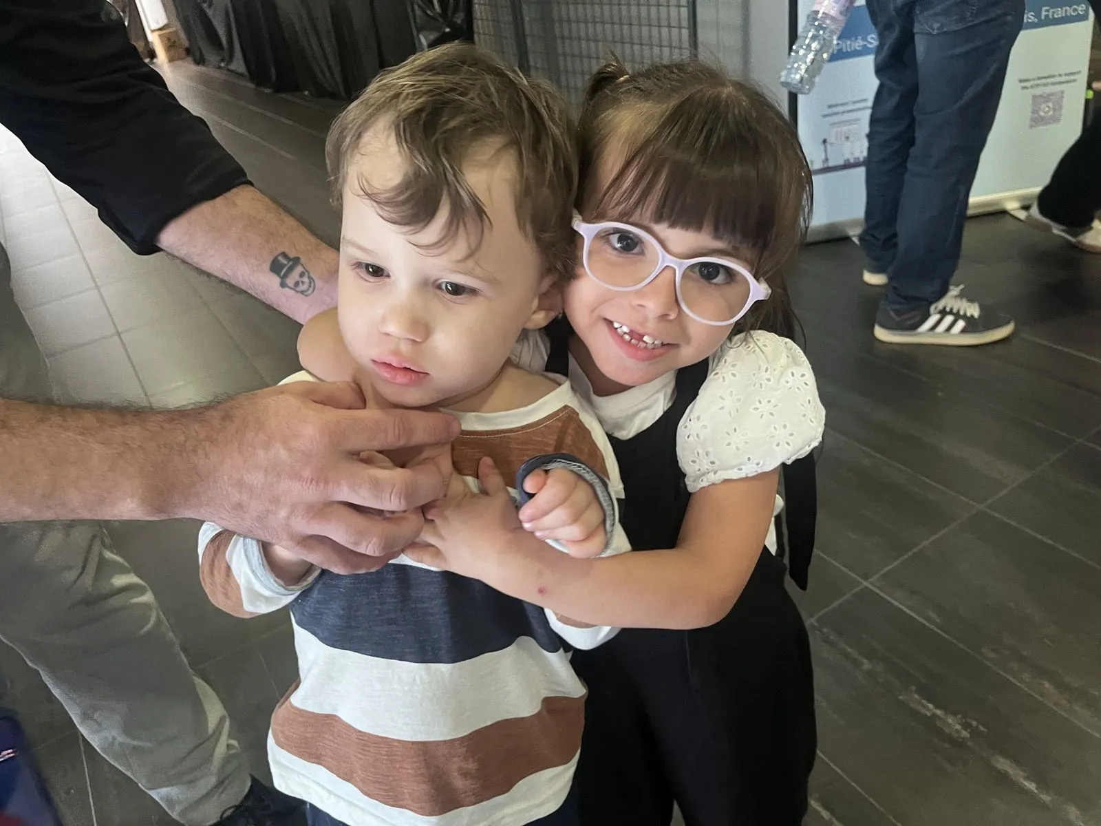 Two children hugging at the symposium