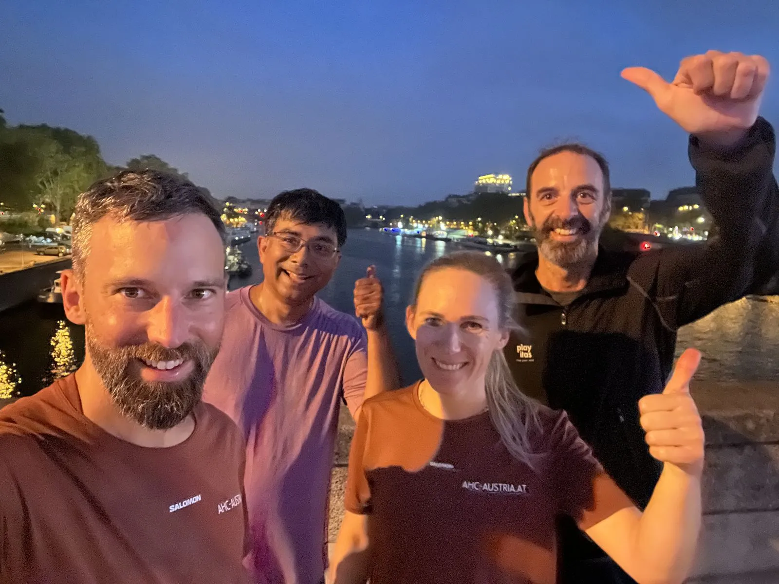 Four runners in AHC Austria shirts on a bridge over the Seine during the first ATP1A3 Morning Run